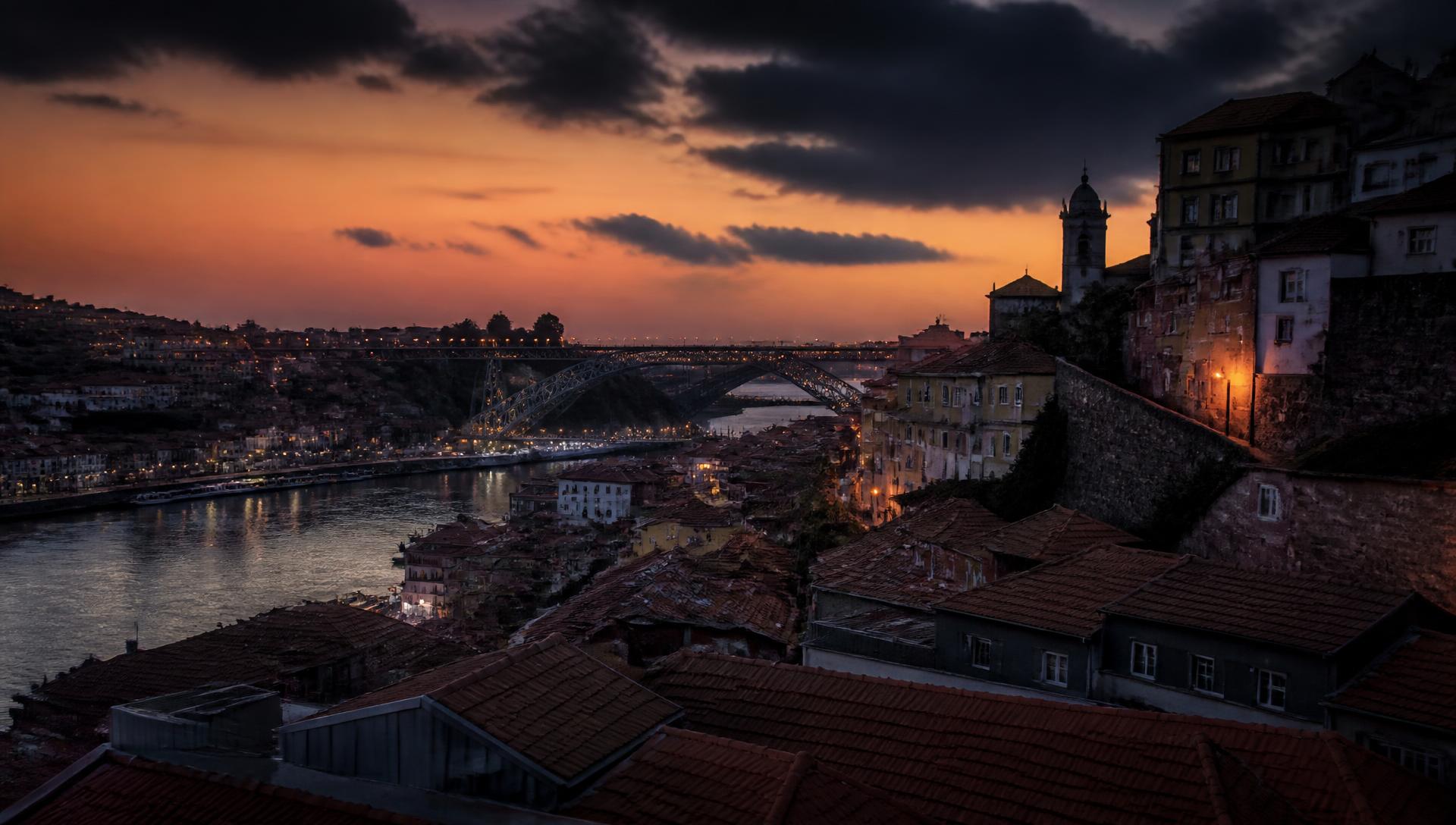 Porto rooftops and the Douro river at dusk with the Dom Luis I bridge